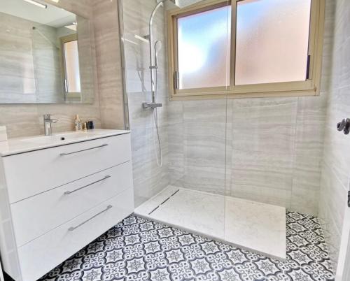 une salle de bain blanche avec une douche et un lavabo dans l'établissement Magnifique appartement vue mer, à Vence