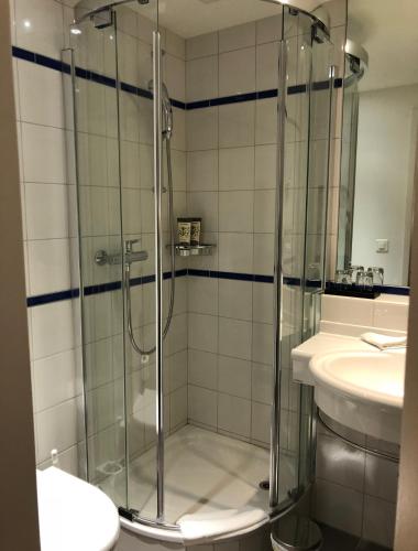 a glass shower in a bathroom with a sink at Hotel Schloss Hünigen in Konolfingen