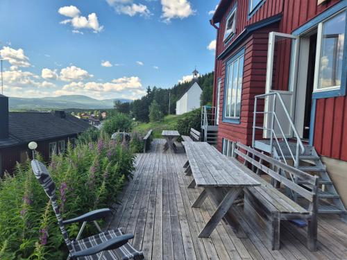 a wooden deck with benches and a building at Prästgården i Funäsdalen in Funäsdalen