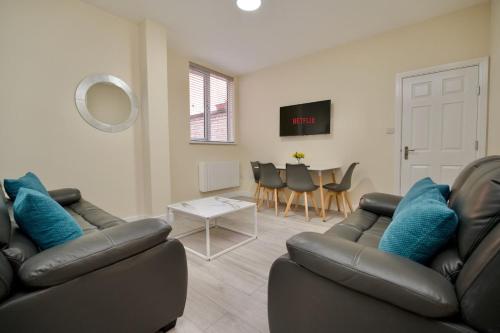 a living room with two leather couches and a table at Warwick Row Apartments Coventry City Centre - Flat 2 in Coventry