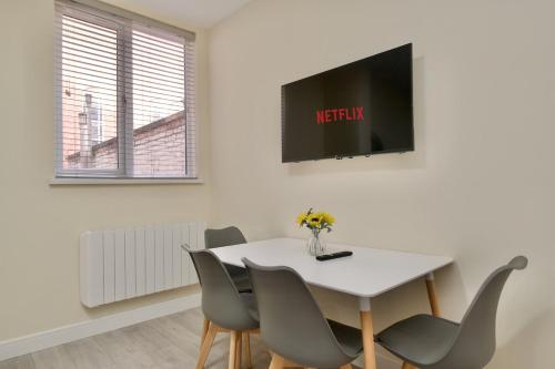 a white dining room with a white table and chairs at Warwick Row Apartments Coventry City Centre - Flat 2 in Coventry