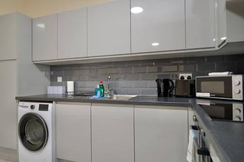 a kitchen with a sink and a washing machine at Warwick Row Apartments Coventry City Centre - Flat 2 in Coventry