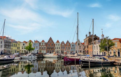 a group of boats docked in a harbor with buildings at Stijlvol Tiny House Zeeland - Centraal gelegen VP022 in Heinkensand