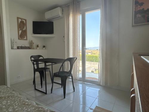 une salle à manger avec une table et des chaises et une fenêtre dans l'établissement Escapade à Carcassonne, à Carcassonne