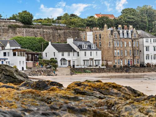 a group of houses on the shore of a beach at 1 Bed in Kinghorn 47388 in Kinghorn