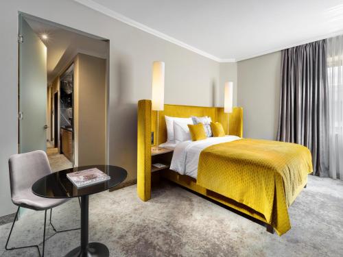 a hotel room with a bed and a table at Mamaison Hotel Chain Bridge Budapest in Budapest