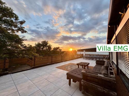a patio with couches and a sunset on a building at Haus EMG Hockenheim in Hockenheim