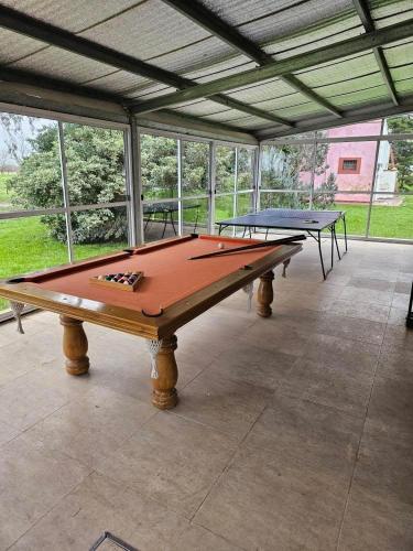 two ping pong tables sitting inside of a building at Campo Cuyen, Cabañas in Lobos