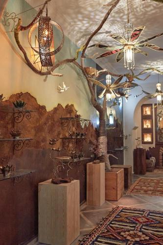 a room with a tree on the wall with chandeliers at Riad Al Ibtikar in Marrakech
