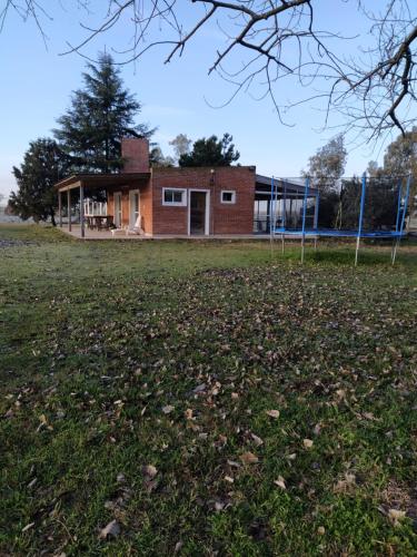 a building with a soccer field in front of it at Campo Cuyen, Cabañas in Lobos