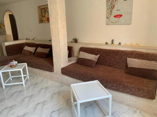 a living room with a couch and a table at Joli Apparetement deux pas à la plage in Hammam Sousse
