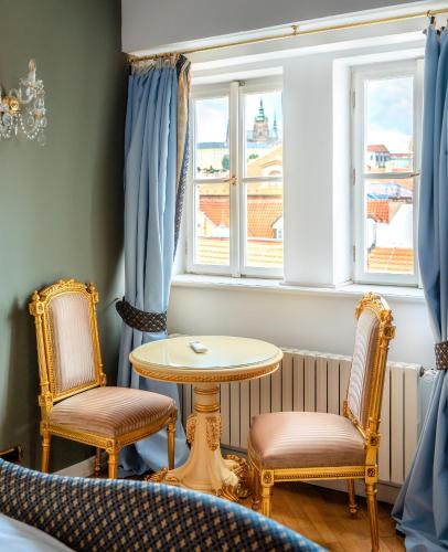 a table and two chairs in a room with a window at Nosticova Heritage in Prague