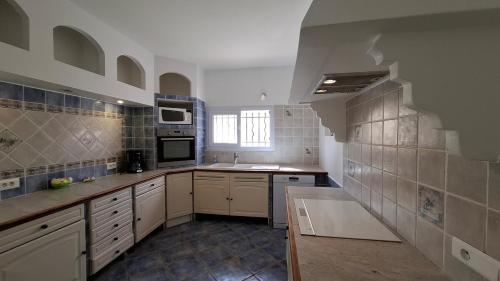 une grande cuisine avec des placards blancs et du carrelage bleu dans l'établissement Villa Sylvana in Provence-Huge Garden, AC and Terrace, à Gonfaron