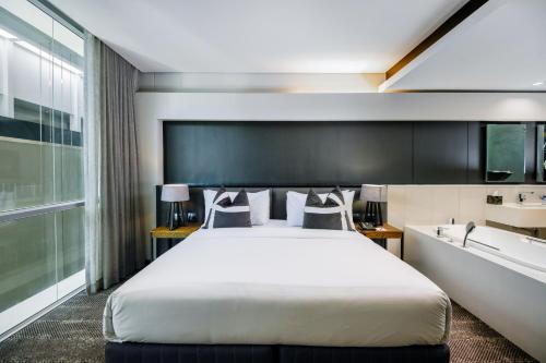 a hotel room with a bed and a bath tub at The Capital 15 on Orange Hotel & Spa in Cape Town