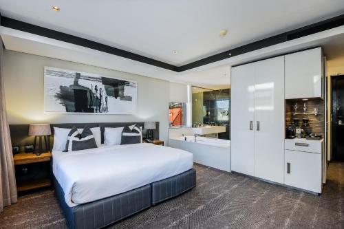 a bedroom with a large bed and a bathroom at The Capital 15 on Orange Hotel & Spa in Cape Town