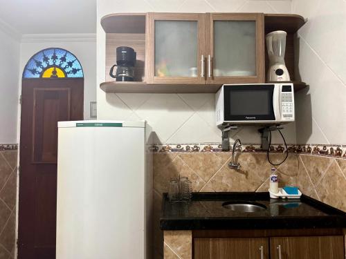 a kitchen with a refrigerator and a sink and a microwave at Casa da Josi - Pajuçara in Maceió