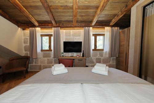 a bedroom with a large bed and a television at Planinarski dom Vošac in Makarska
