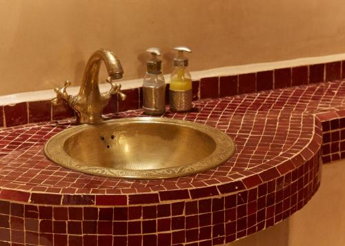 a bathroom sink with two bottles of soap on it at Riad Al Ibtikar in Marrakech