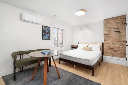 a bedroom with a bed and a table at MTL Central Stay Apartments in Montréal