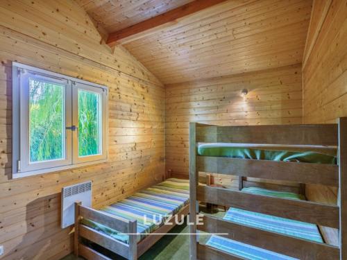 a log cabin with two bunk beds in it at Gîte des fleurs - 5 Chalets in Saint-Prix