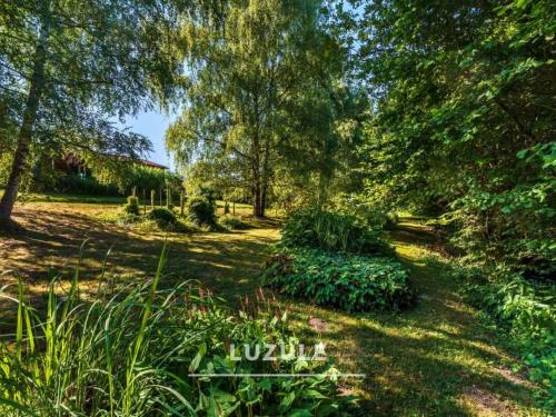 a garden with trees and plants in a field at Gîte des fleurs - 5 Chalets in Saint-Prix