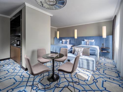 a bedroom with a bed and a table and chairs at Mamaison Hotel Chain Bridge Budapest in Budapest