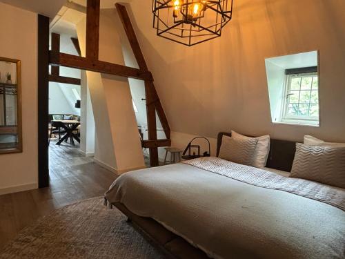 GrubbenvorstにあるIn de Witte Dame Hotel Bar Kitchen Apartmentsの大きなベッドとシャンデリアのある寝室