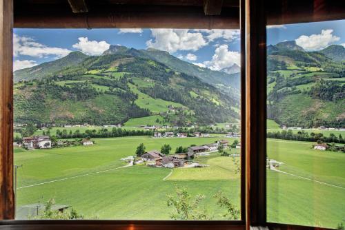 a window view of a green field and mountains at Berghaus Glosaleite Zillertal in Zellberg