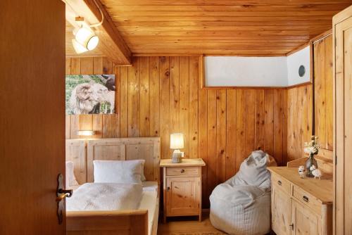 a bedroom with wooden walls and a bed and a desk at Berghaus Glosaleite Zillertal in Zellberg