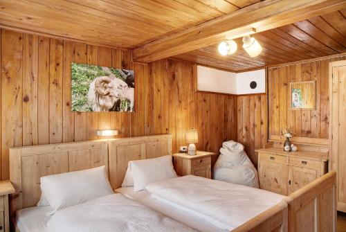 a bedroom with two beds in a wooden room at Berghaus Glosaleite Zillertal in Zellberg