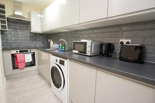 a kitchen with a washer and dryer on a counter at Warwick Row Apartments Coventry City Centre - Flat 4 in Coventry