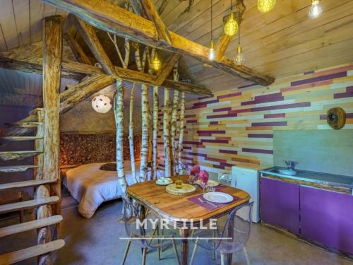 a room with a table and a bed in a room at Gîte des fleurs - 5 Chalets in Saint-Prix
