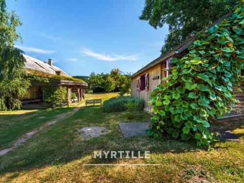 an old barn with a large ivy growing on it at Gîte des fleurs - 5 Chalets in Saint-Prix