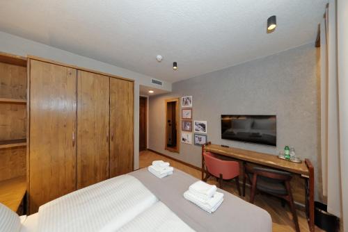 a bedroom with a bed and a desk and a television at Planinarski dom Vošac in Makarska