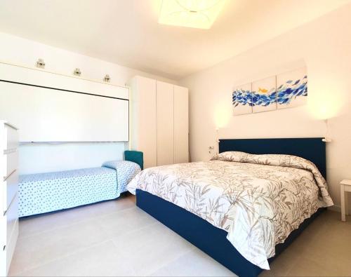 a bedroom with a bed and a chair in it at MK Apartments in Lido di Jesolo