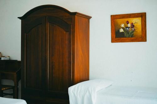 a bedroom with a bed and a wooden cabinet at Agriturismo Vallerana in Capalbio
