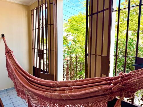 a hammock in a room with a window at Casa da Josi - Pajuçara in Maceió
