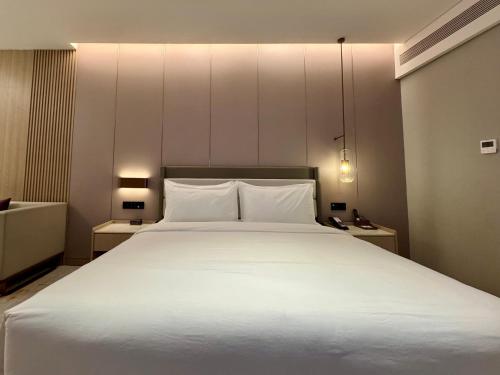 Un ou plusieurs lits dans un hébergement de l'établissement Elong Hotel Jakarta PIK