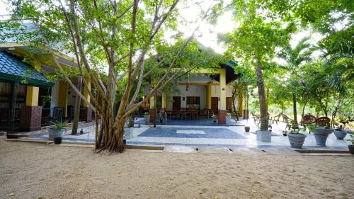 a building with a tree in front of it at The Nature Resort in Dambulla