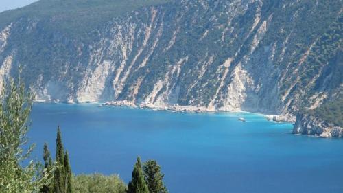 a view of a blue lake in the mountains at Hotel Nostos in Frikes