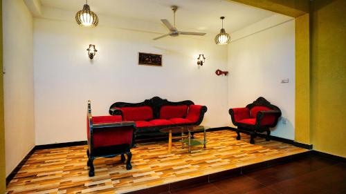 a living room with two red couches and a table at The Nature Resort in Dambulla