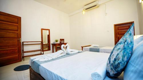 a bedroom with two beds with towels on them at The Nature Resort in Dambulla