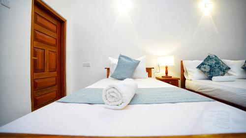 a bedroom with two beds with blue and white pillows at The Nature Resort in Dambulla