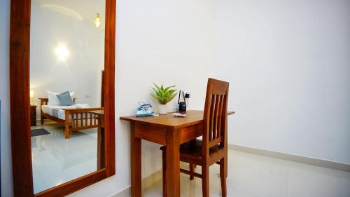 a mirror and a wooden table and chair in a room at The Nature Resort in Dambulla