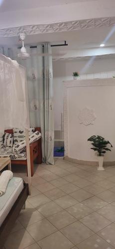 a room with a bed and a plant on a wall at L & C Chinese Studio in Diani Beach