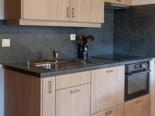 une cuisine avec un évier et une cuisinière dans l'établissement Superbe appartement 5 pers avec balcon au Grand-Bornand - FR-1-467-86, au Grand-Bornand