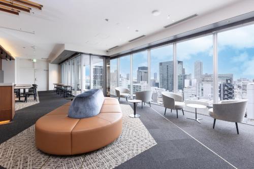 un bureau avec un canapé, des chaises et des fenêtres dans l'établissement Tokyu Stay Osaka Hommachi, à Osaka