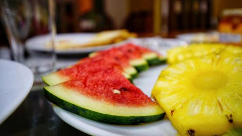 a plate with slices of watermelon and a slice of pineapple at The Nature Resort in Dambulla