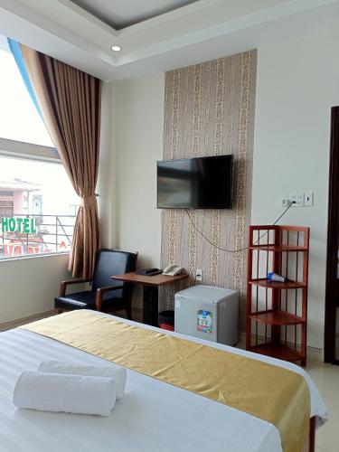 a hotel room with a bed and a tv at VẠN LỘC HOTEL in Can Tho