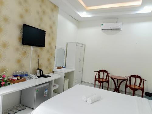 a room with a bed and two chairs and a tv at VẠN LỘC HOTEL in Can Tho